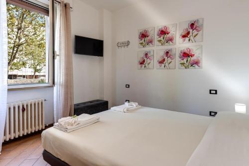 two beds in a room with a window and two paintings on the wall at Apartment for 2 Florence Redi in Florence