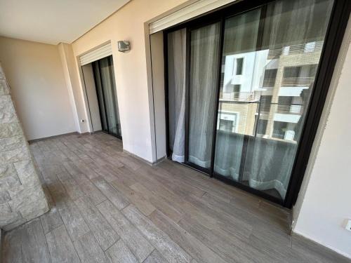 an empty room with a large glass window at Cozy Beach Stay with Pool Near Rabat in Sidi Bouqnadel