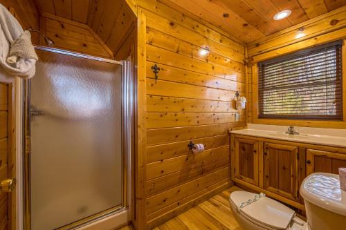 a bathroom with a shower and a toilet and a sink at Bear Pause Cabin by American Patriot Getaways in Glade