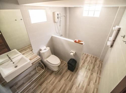 a bathroom with a white toilet and a sink at Dusadee Lim Yoga & Qigong Retreat August 2025 in Ko Phangan