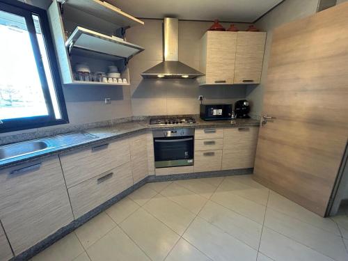a kitchen with a stove top oven next to a window at Cozy Beach Stay with Pool Near Rabat in Sidi Bouqnadel