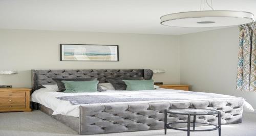 a bedroom with a large bed with a large headboard at The Clarence Gardens Hotel, BW Signature Collection in Scarborough