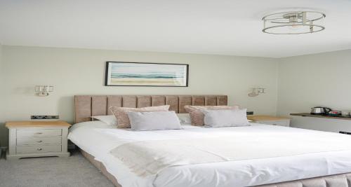 a bedroom with a large bed with white sheets and pillows at The Clarence Gardens Hotel, BW Signature Collection in Scarborough