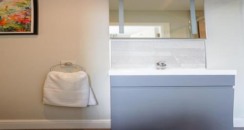 a bathroom with a white sink and a mirror at The Clarence Gardens Hotel, BW Signature Collection in Scarborough