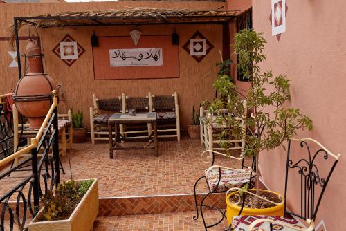 a patio with a table and chairs and plants at Riad Parfums de OUARZAZATE in Ouarzazate