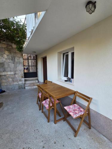 a wooden table and two chairs on a patio at Apartman u centru Komiže in Komiža