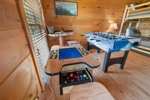 a room with two game tables in a cabin at Beneath The Stars by American Patriot Getaways in Hatchertown