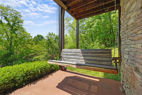 a wooden bench sitting on a porch with a window at Beneath The Stars by American Patriot Getaways in Hatchertown