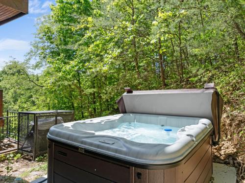 a hot tub in a backyard with trees at Beneath The Stars by American Patriot Getaways in Hatchertown