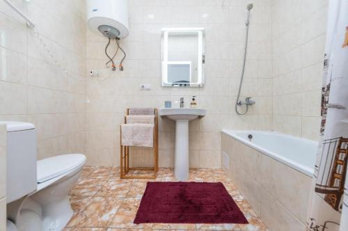 Un baño con lavabo, bañera e inodoro. en ЖК "Ривьера", en Kiev