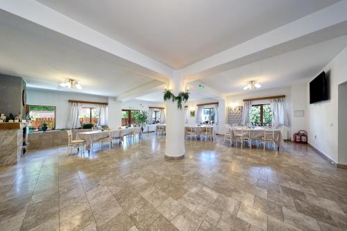 a large living room with tables and chairs at Pensiunea Anotimpuri Bran in Bran