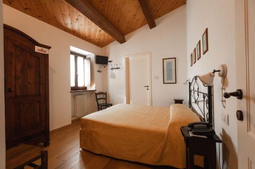 a bedroom with a bed in a room with wooden ceilings at Agriturismo Antico Muro in Sassoferrato