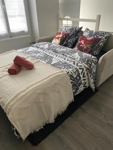 a bed with a blanket and pillows on it at Le Dagonneau in Varennes Vauzelles
