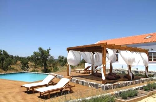 a deck with chairs and a pavilion next to a pool at GR ALENTEJO HILLS Nature & Tranquility! Beach 35m in Grândola