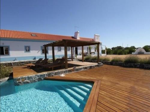 a swimming pool with a wooden deck and a gazebo at GR ALENTEJO HILLS Nature & Tranquility! Beach 35m in Grândola