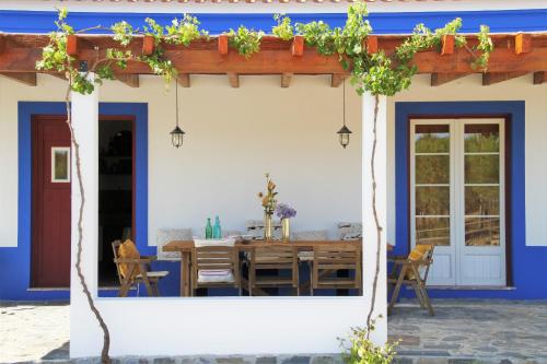 a blue and white house with a wooden table at GR ALENTEJO HILLS Nature & Tranquility! Beach 35m in Grândola