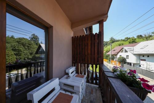 a balcony with a table and chairs and a window at Pensiunea Anotimpuri Bran in Bran