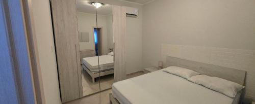 a small room with a bed and a mirror at Short Location Paratore Casa Melina in Catania