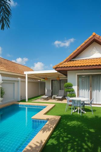 a house with a swimming pool and a table and chairs at View Talay 2-BR Luxury Villa Private Pool-5 Min To Beach in Jomtien Beach