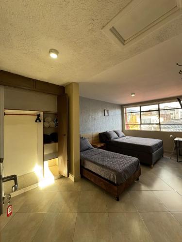 ボゴタにあるHostelfc Movistar57のベッド2台とソファのある寝室