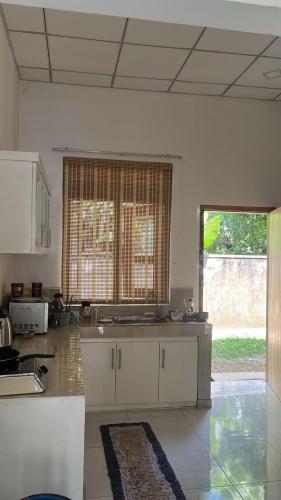 a kitchen with white cabinets and a large window at Dolahena Chalet 2 