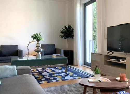 a living room with a couch and a tv at MM1 Cosy & Central Apartment in Baixa with Castle View and Free Parking! in Lisbon