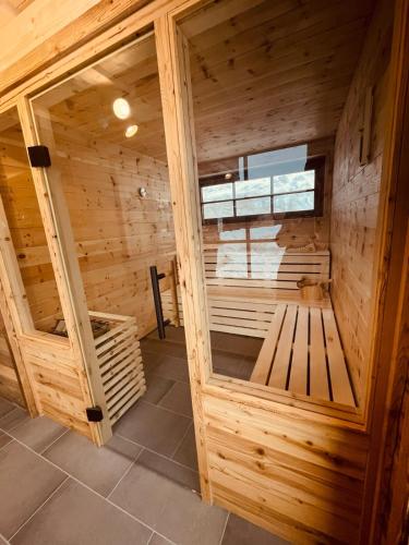 a wooden sauna with a bench in the middle at SEPPKEUSCHE - historisches Chalet mit Zirbensauna und Hotpot in Turracher Hohe