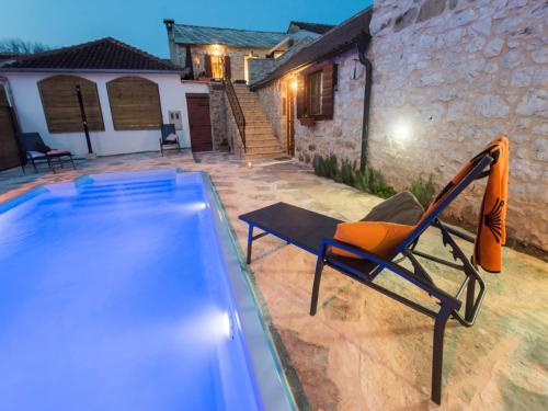 a chair sitting next to a swimming pool at Holiday Home near Vrana Lake and Adriatic Sea in Benkovac