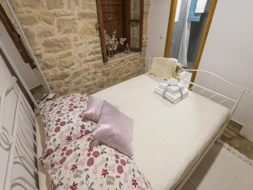 a small bedroom with a bed and a stone wall at Holiday Home near Vrana Lake and Adriatic Sea in Benkovac