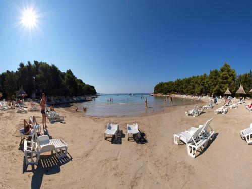 a beach with lounge chairs and people in the water at Holiday Home near Vrana Lake and Adriatic Sea in Benkovac