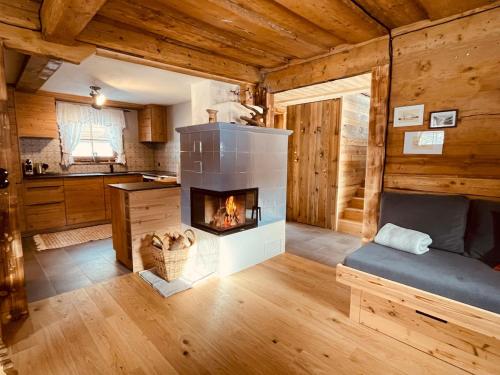 a living room with a fireplace in a log cabin at SEPPKEUSCHE - historisches Chalet mit Zirbensauna und Hotpot in Turracher Hohe