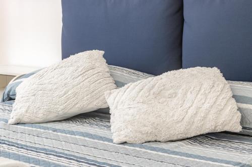 two pillows sitting on top of a bed at H11 MAISON BLEU Centro - Ariston in Sanremo