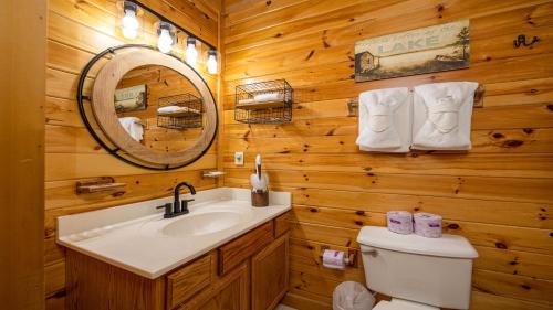 a bathroom with a sink and a toilet and a mirror at Panoramic Peak by American Patriot Getaways in Walnut Grove