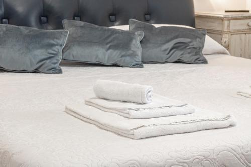 a pile of towels sitting on top of a bed at H11 MAISON BLEU Centro - Ariston in Sanremo