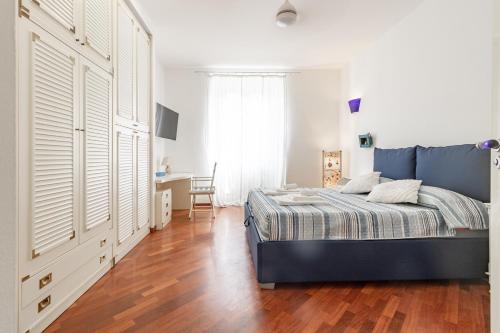 a bedroom with a bed and a desk in it at H11 MAISON BLEU Centro - Ariston in Sanremo