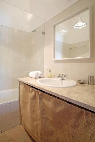 a bathroom with a sink and a mirror and a tub at ST Pool Gardens SESIMBRA,Tranquility Beach 10min in Sesimbra