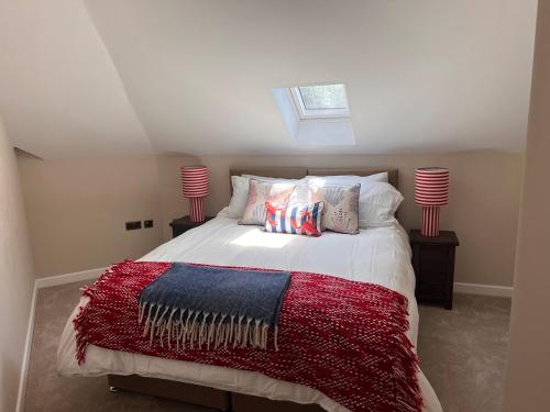 a bedroom with a bed with a red blanket and two lamps at St Kitts By the Sea, at Sandgate in Sandgate
