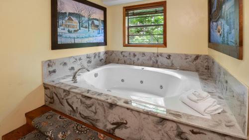 Una bañera grande en un baño con ventana. en Up the Creek by American Patriot Getaways, en Chalet Village