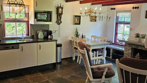 a kitchen with a table and chairs and a sink at Vakantiehuis "It koaihûs" in Jistrum