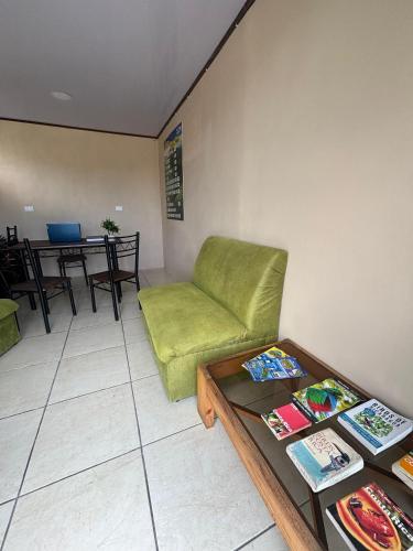 a living room with a green couch and a table at Hotel Nativo Arenal in Fortuna