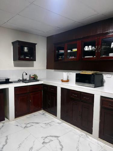 a kitchen with wooden cabinets and a microwave at Newly Remodeled Villa Las Flores, 11 guests 