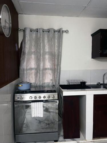 a kitchen with a stove with a transparent curtain over it at Newly Remodeled Villa Las Flores, 11 guests 