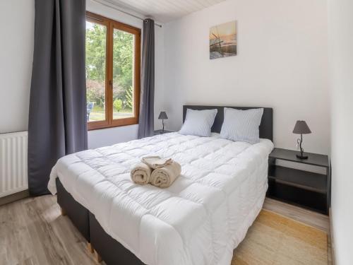 una camera da letto con un grande letto bianco con due asciugamani sopra di Dordogne Poolside Escape a Villeneuve-sur-Lot