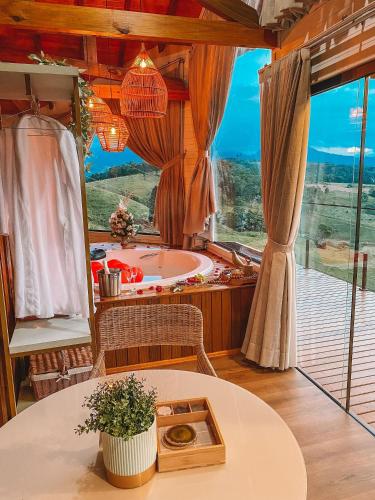 a bathroom with a tub and a table and a window at Sítio Recanto Azul in Barracão