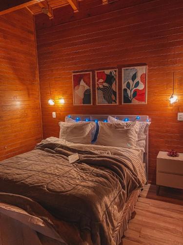 a bedroom with a large bed in a wooden wall at Sítio Recanto Azul in Barracão