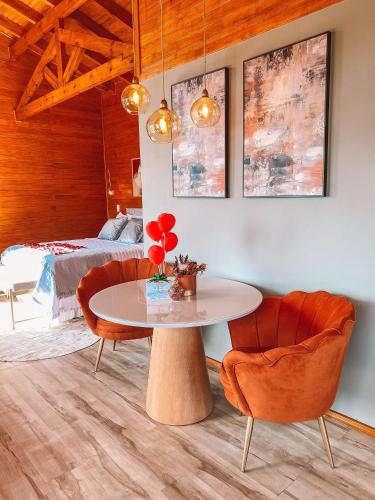 a room with a table and two chairs and a bed at Sítio Recanto Azul in Barracão