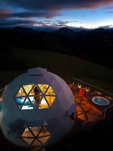 a person standing inside of a circular building with a view at Sítio Recanto Azul in Barracão