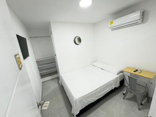 a small room with a bed and a desk at Hotel Santa Marta VIP in Santa Marta