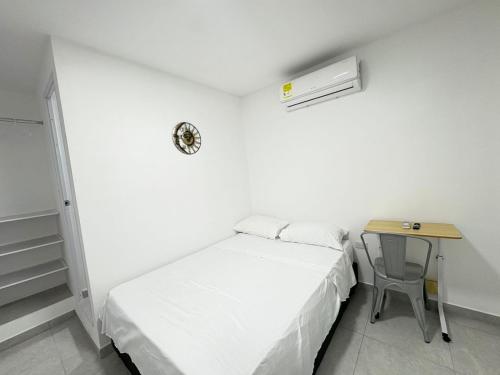 a small bedroom with a bed and a desk at Hotel Santa Marta VIP in Santa Marta