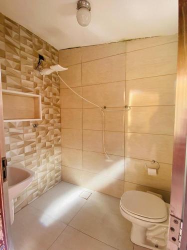 a bathroom with a toilet and a sink at Casa da vovó Marta in Itanhaém